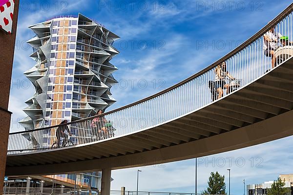 Cyclists on bridge at Kaktus Tower skyscraper, Cykelslangen bicycle bridge