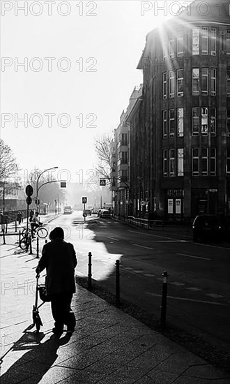 Black and white, senior citizen with walker on the pavement