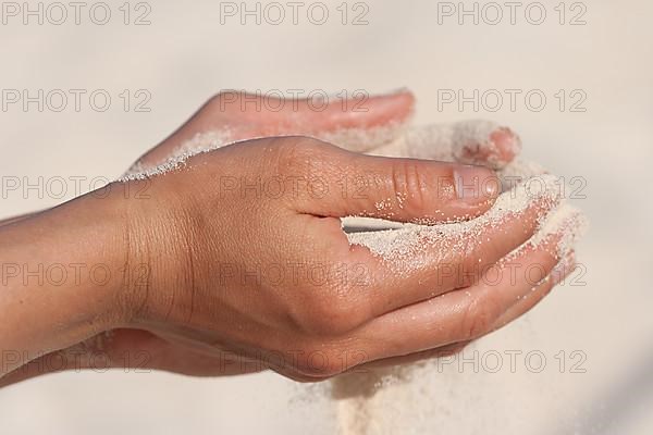 Sand running through hands n beach