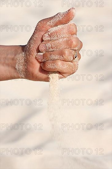 Sand running through hands n beach