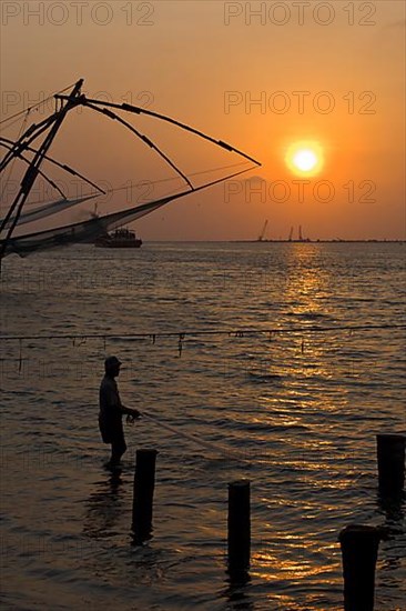 Fisherman and Kochi chinese fishnets on sunset. Fort Kochin