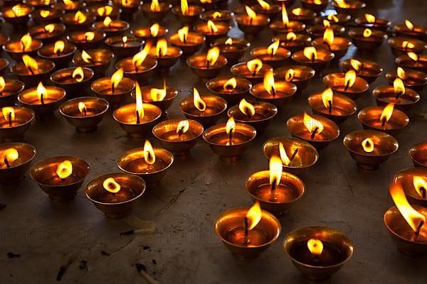 Burning candles in Buddhist temple. Tsuglagkhang complex