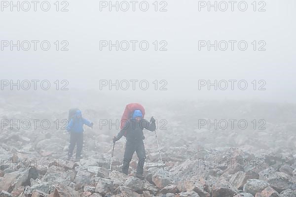 2 men with trekking equipment in rocky landscape