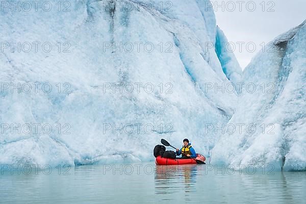 Man with packraft at sea