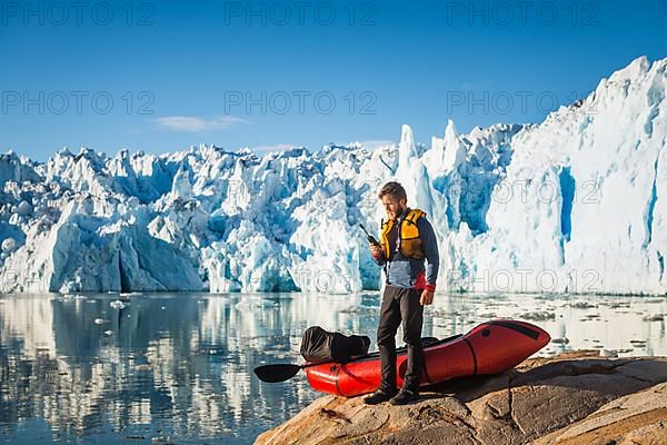 Man with packraft on fjord