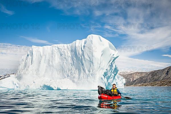 Man with packraft on fjord