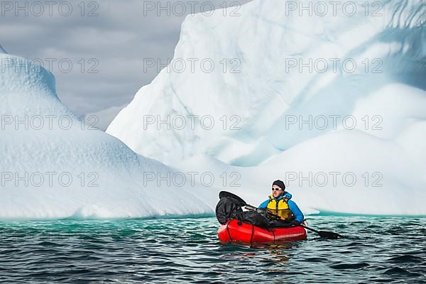 Man with packraft on fjord