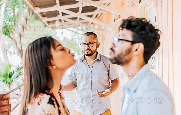 Man discovering his cheating girlfriend kissing another man in the street