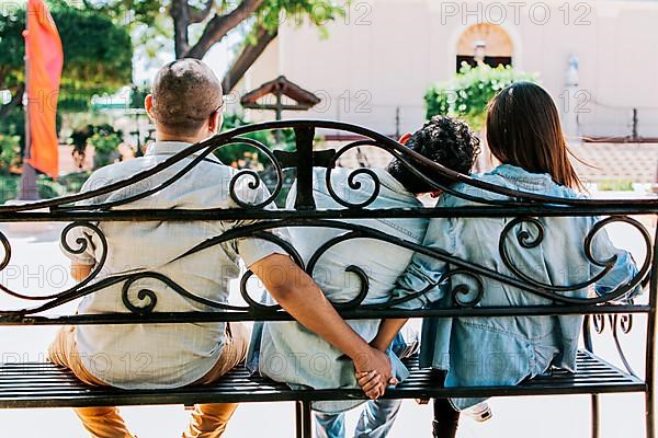 Unfaithful couple holding hands on a park bench