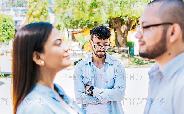 Sad man seeing his girlfriend cheating with his friend outdoors