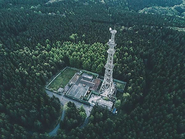 AERIAL: Drone Shot of old Abandones Radio Tower Station in Rich Green Forest surrounded by Trees HQ