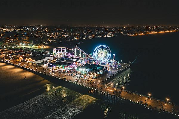 Circa November 2019: Santa Monica Pier at Night in super colourful lights from Aerial Drone perspective in Los Angeles