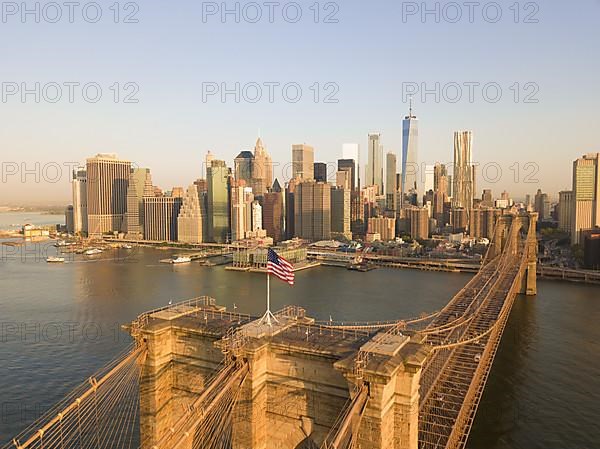 Brookyln Bridge Aerial view with American Flag waving and Manhattan Skyline in the background in Daylight HQ