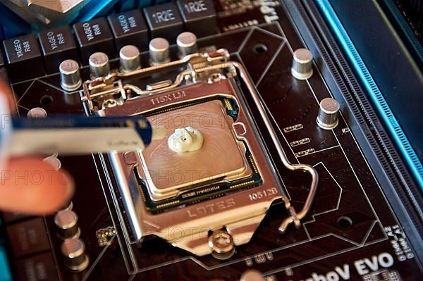 Applying thermal paste to the central processor of the motherboard close up