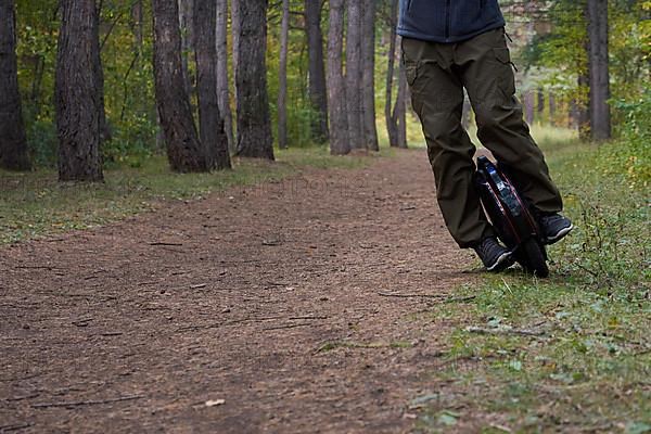 Front view of male legs on a unicycle in the forest