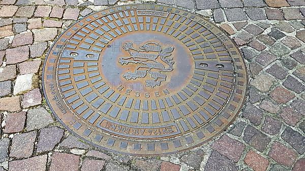 Manhole cover with the coat of arms of Seligenstadt. Seligenstadt