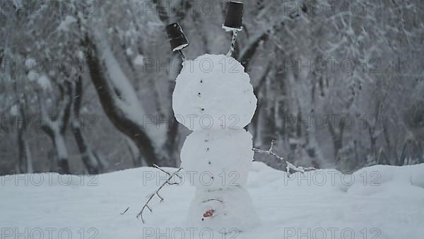 Happy funny snowman acrobat standing on his head