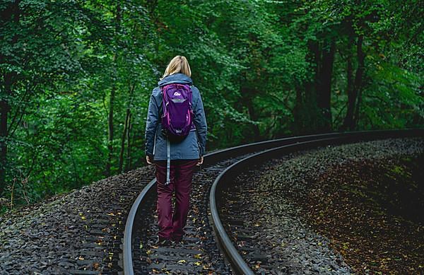 Woman running through the forest on the tracks of the Rasender Roland