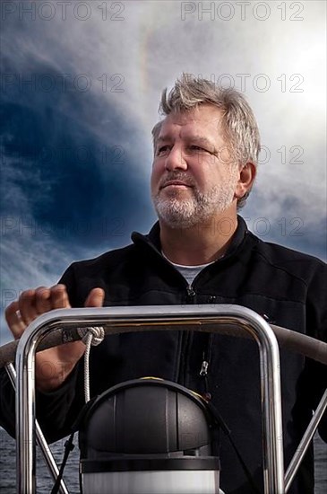 Skipper at the helm of his sailing yacht