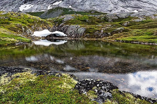 Remnants of snow and rocks reflected in the water