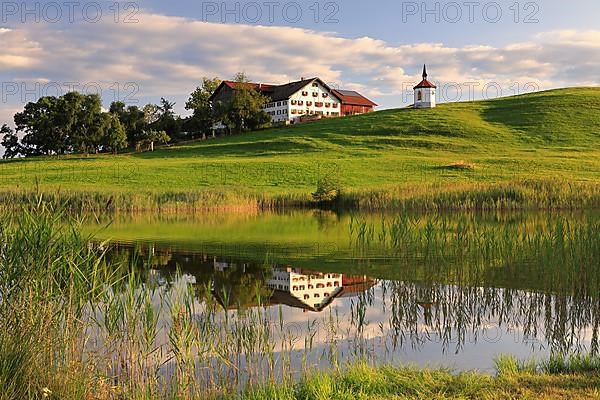 Lake chapel and farmhouse reflected in the lake