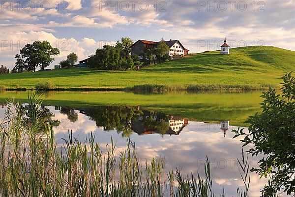 Lake chapel and farmhouse reflected in the lake