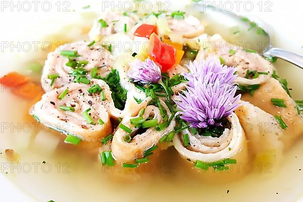 Delicious Braet Strudel soup served in a plate and garnished with chives and chive blossoms