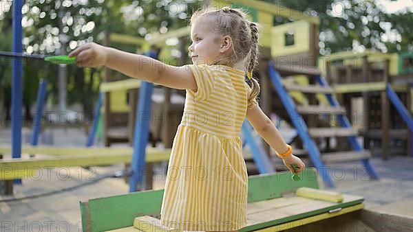 Cute little girl is playing in the sandbox on the playground. Child girl playing on the playground in the city park. Odessa