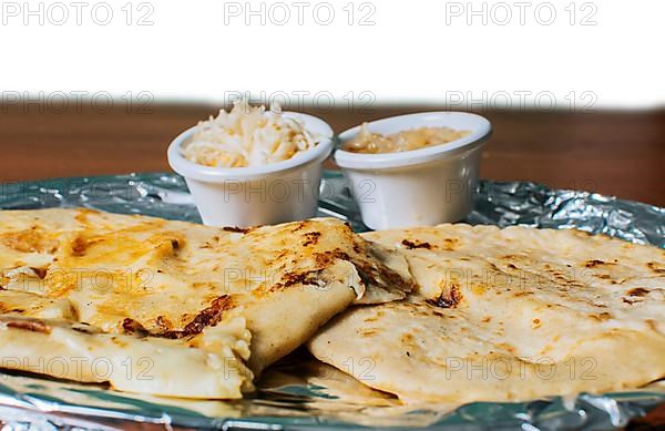 Close up of delicious Salvadoran pupusas with cheese served on the table. Traditional pupusas served with salad on the table. Two Nicaraguan pupusas with salad on the table