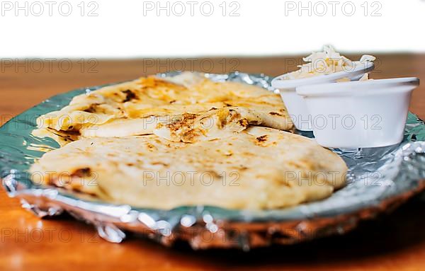 Traditional pupusas served with salad on the table. Two Nicaraguan pupusas with salad on the table