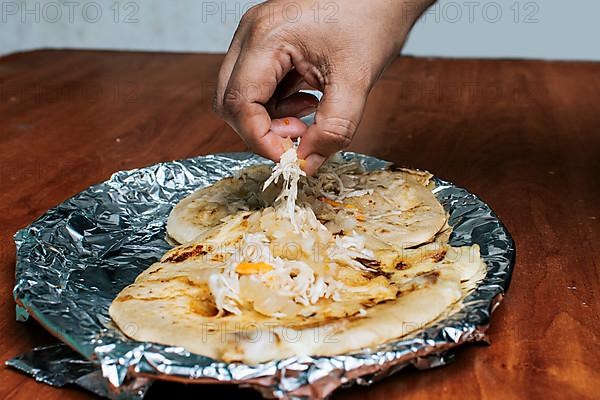 Nicaraguan pupusas with salad on aluminum foil