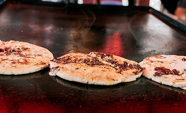 Three traditional Nicaraguan pupusas with melted grilled cheese