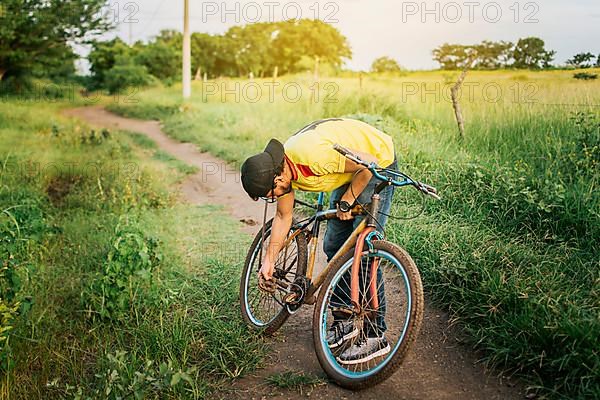 Man repairing his bike in the middle of the road