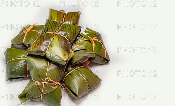 View of homemade Nicaraguan nacatamales with banana leaf on white background