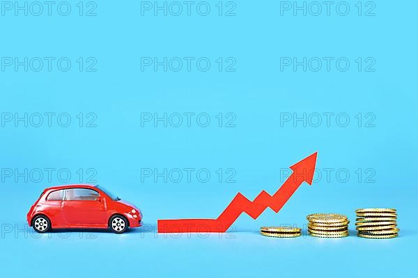 Small car with rising arrow and money coins on blue background