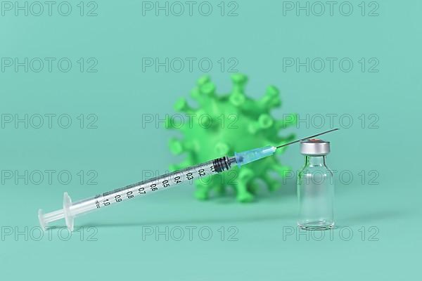 Vaccine vial with syringe and corona virus model in background