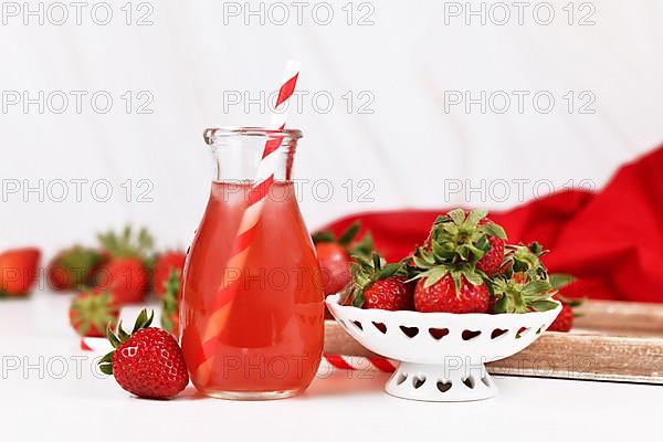 Red strawberry fruit lemonade in jar with raw berries