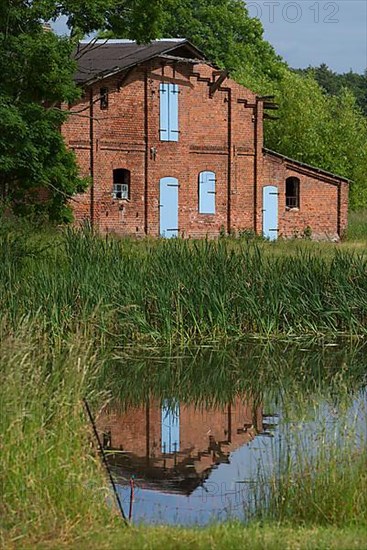 Former pigsty reflected in the pond