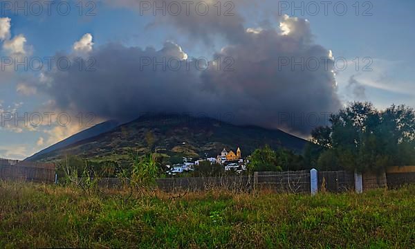 Small fishing village and harbour of San Vincenzo in front of the volcanic cone of Stromboli at sunset