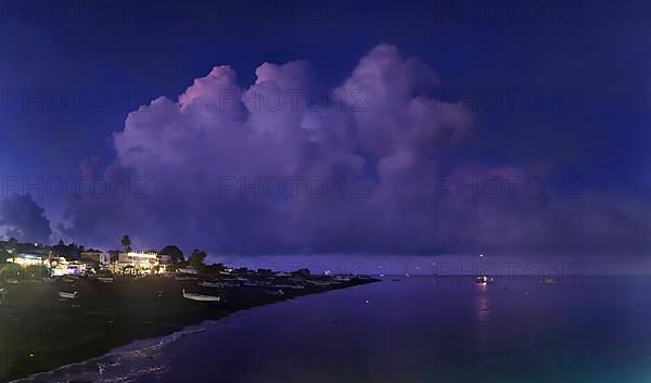 Beach of the fishing village San Vincenzo with fishing boats at sunset and bizarre cloudscape