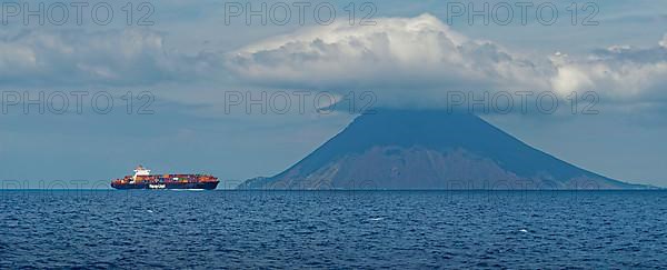 Container ship in front of the island and volcano Stromboli