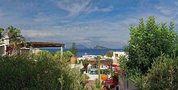 Town of Panarea with view of the small island Le Guglie of a former volcano and the volcanic island Stromboli