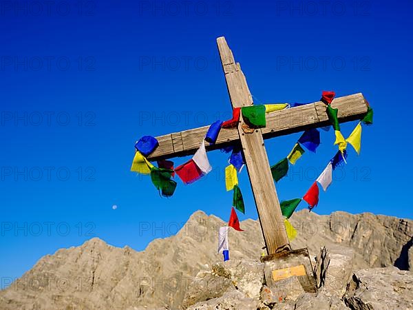 Buddhist prayer flags at the summit cross of the Kleiner Watzmann