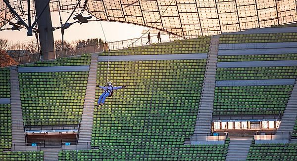 Woman swinging on a zip line above the Olympic Stadium