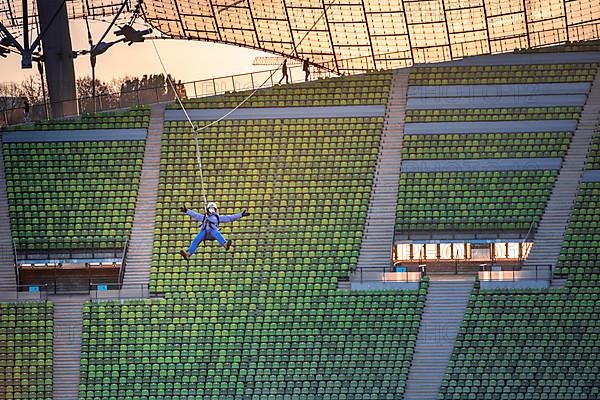 Woman swinging on a zip line above the Olympic Stadium
