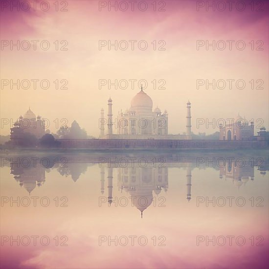 Vintage retro hipster style image of Taj Mahal on sunrise sunset reflection in Yamuna river panorama in fog