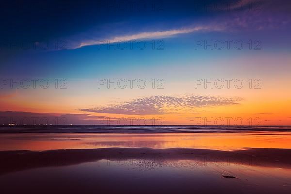 Vintage retro hipster style travel image of sunset on Baga beach. Goa