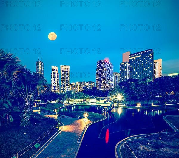 Vintage retro hipster style travel image of skyline of Central Business District of Kuala Lumpur in night