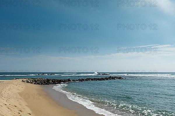 Wave breaker on beach. Mirissa