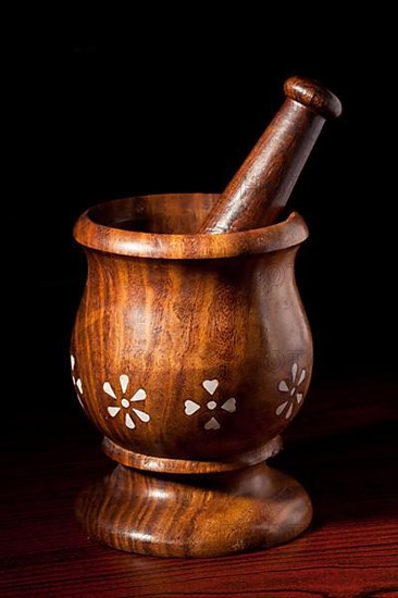 Wooden mortar and pestle on dark wood background